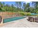 Backyard with in-ground pool, patio dining set, and lush greenery creating a private oasis at 5178 Stefan Ridge Way, Buford, GA 30519