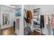 Walk-in closet with wood floors, rod, shelves, mirror, and a collection of clothing at 5178 Stefan Ridge Way, Buford, GA 30519