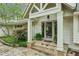 A covered entryway with stone steps leads to double doors framed by white columns and greenery at 5251 Powers Ferry Rd, Atlanta, GA 30327
