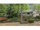 Charming home with stone walls, landscaping, and a driveway, set amidst mature trees and flowering bushes at 5251 Powers Ferry Rd, Atlanta, GA 30327