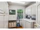 Well-organized laundry room with white cabinets, modern washer and dryer, and a convenient folding station at 5251 Powers Ferry Rd, Atlanta, GA 30327