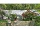 The private tennis court with access via steps leading through lush landscaping, creates a private playing experience at 5251 Powers Ferry Rd, Atlanta, GA 30327