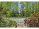 The property has a private tennis court surrounded by lush greenery and vibrant flowering plants at 5251 Powers Ferry Rd, Atlanta, GA 30327