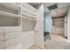 Spacious walk-in closet with custom shelving and a cozy bench seating area at 5251 Powers Ferry Rd, Atlanta, GA 30327