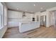 Bright kitchen with white cabinetry, stainless steel appliances, and an island with a sink at 623 Leafy Branch Way, Mcdonough, GA 30253