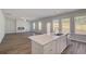 Modern kitchen with stainless steel appliances, a center island, and views into the living room at 623 Leafy Branch Way, Mcdonough, GA 30253