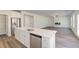 Open kitchen with stainless appliances, island with sink, and view into the living area at 623 Leafy Branch Way, Mcdonough, GA 30253