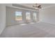 The spacious main bedroom features neutral carpet, tray ceiling, and plenty of natural light from its large windows at 623 Leafy Branch Way, Mcdonough, GA 30253