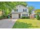 Charming two-story home with a well-manicured lawn and attached garage, framed by mature trees at 912 Third St, Stone Mountain, GA 30083