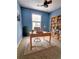 Bright home office featuring a ceiling fan, a built-in bookcase, and a large window with blinds at 10900 Wittenridge Dr # H8, Alpharetta, GA 30022
