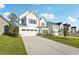 Beautiful single-Gathering home with a concrete driveway, lovely lawn, and multiple neighboring homes in the background at 11850 Rizvan Pl, Covington, GA 30014