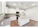 Bright kitchen boasts granite counters, center island, stainless steel appliances and stylish pendant lighting at 11850 Rizvan Pl, Covington, GA 30014