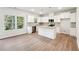 Open concept kitchen with white cabinets, an island with granite counters and stainless steel appliances at 11850 Rizvan Pl, Covington, GA 30014