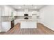 Spacious open kitchen features an island, stainless appliances, and white cabinets offering a modern aesthetic at 11850 Rizvan Pl, Covington, GA 30014