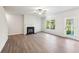 Bright living room features a fireplace, ceiling fan, wood-look floors, and a door to the outside at 11850 Rizvan Pl, Covington, GA 30014