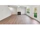 Bright living room features a fireplace, ceiling fan, wood-look floors, and a door to the outside at 11850 Rizvan Pl, Covington, GA 30014