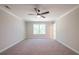 Spacious bedroom with neutral carpet, a ceiling fan, and a bright window at 1624 Ruskin Way, Marietta, GA 30062