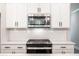 Stylish kitchen with stainless steel microwave and gas range, white cabinets, and subway tile backsplash at 1624 Ruskin Way, Marietta, GA 30062