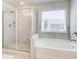 Modern bathroom features a glass-enclosed shower and a soaking tub, offering spa-like amenities at 42 Citrine Way, Acworth, GA 30101