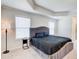 Well-lit bedroom boasts tray ceilings and a plush bed, creating a relaxing retreat at 42 Citrine Way, Acworth, GA 30101