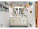Bright bathroom with a double vanity, decorative mirrors, updated fixtures, and storage at 5837 Fox Run, Rex, GA 30273