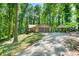View of the house with two-car garage and a carport accessible via a long driveway through a forest at 5837 Fox Run, Rex, GA 30273