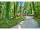 View of the house with two-car garage and a carport accessible via a long driveway through a forest at 5837 Fox Run, Rex, GA 30273