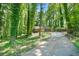 View of the house with two-car garage and a carport accessible via a long driveway through a forest at 5837 Fox Run, Rex, GA 30273