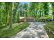 View of the house with two-car garage and a carport accessible via a long driveway through a forest at 5837 Fox Run, Rex, GA 30273