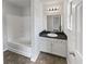 Bathroom features vanity with dark countertop, a tub, and modern lighting at 105 Odyssey Turn, Conyers, GA 30012