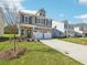 Beautiful two-story house showcasing a brick front, two-car garage, and an expansive green lawn at 11854 Rizvan Pl, Covington, GA 30014