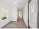 Bright hallway featuring sleek flooring, fresh paint, and a window offering a glimpse of the outdoors at 11854 Rizvan Pl, Covington, GA 30014