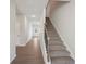Bright foyer showcasing a staircase with carpeted steps and a modern black railing at 11854 Rizvan Pl, Covington, GA 30014