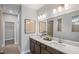Bathroom featuring double vanity with quartz countertop, large mirror, and modern fixtures at 244 Nesta Grove, Locust Grove, GA 30248