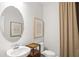 Elegant powder room with pedestal sink, oval mirror, and refined decor, maximizing small space at 244 Nesta Grove, Locust Grove, GA 30248