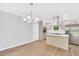 Open concept kitchen and dining area with modern light fixture, stainless steel appliances, and deck access at 3355 Wesley Chapel Rd, Decatur, GA 30034