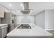 Open concept kitchen featuring a kitchen island with marble countertop and cooktop with stainless steel appliances and exhaust hood at 3355 Wesley Chapel Rd, Decatur, GA 30034
