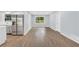 A bright living room with wood floors, stainless steel fridge, and a large window at 3355 Wesley Chapel Rd, Decatur, GA 30034