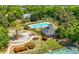 Aerial view of neighborhood pool, tennis court and clubhouse surrounded by mature landscaping and trees at 4044 Andover Cir, Mcdonough, GA 30252