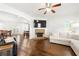 Open concept living room featuring a brick fireplace and hardwood floors at 4044 Andover Cir, Mcdonough, GA 30252