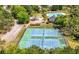Aerial view showcasing the community's tennis courts with pool, clubhouse, landscaping, and surrounding trees at 4044 Andover Cir, Mcdonough, GA 30252