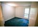 Empty bedroom featuring blue carpet, a window, and a neutral wall color at 4190 Heather Way, Cumming, GA 30041