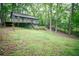 Exterior view of a single Gathering home with a deck surrounded by mature trees and lush greenery at 4190 Heather Way, Cumming, GA 30041