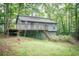 Exterior view of a single Gathering home with a deck surrounded by mature trees and lush greenery at 4190 Heather Way, Cumming, GA 30041