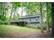 Exterior view of a single Gathering home with a deck surrounded by mature trees and lush greenery at 4190 Heather Way, Cumming, GA 30041