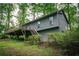 Exterior view of a single Gathering home with a deck surrounded by mature trees and lush greenery at 4190 Heather Way, Cumming, GA 30041
