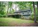Exterior view of a single Gathering home with a deck surrounded by mature trees and lush greenery at 4190 Heather Way, Cumming, GA 30041