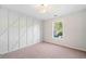 Empty bedroom featuring neutral carpet, geometric accent wall, and a large window at 139 Thunder Ridge Ln, Acworth, GA 30101