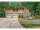 Two-story home with a stone chimney, two-car garage, and a cozy screened porch at 1415 Hialeah Ct, Marietta, GA 30062