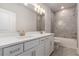 Well-lit bathroom with double sink vanity, quartz countertops, and modern gray tiled tub with shower at 3139 Hilltop Drive, Marietta, GA 30066